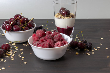 yoghurt with probiotic in a glass beaker with fruit on a dark wooden table