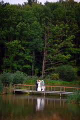 Wedding couple in love on wedding day The groom holds the bride in her arms near beautiful lake in forest. selective focus