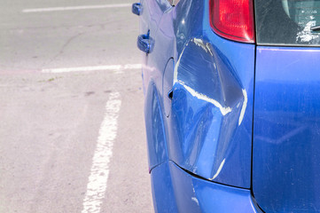 Blue scratched car with damaged paint in crash accident or parking lot and dented damage of metal body from collision © Srdjan