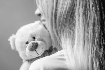 portrait of a girl with a happy soft toy bear