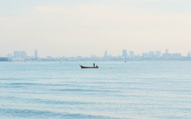 The fisherman standing on fishing boat and driving to the land.