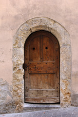 Old door with eroded stone arch in the city Sion, Switzerland