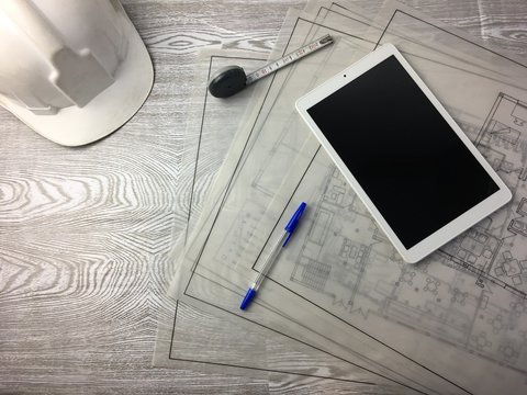 Mesa De Trabajo De Arquitecto Con Planos Y Tablet.