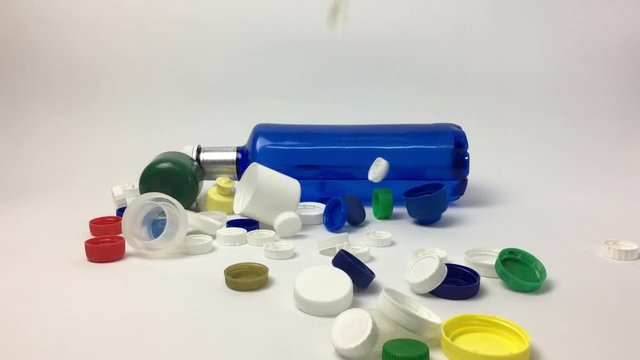 Escena con botella de plastico y tapones cayendo.