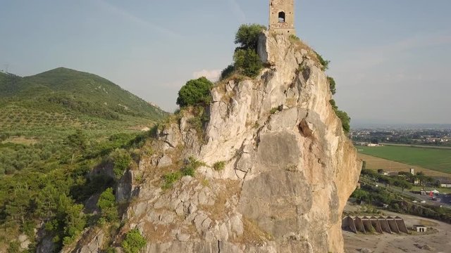 Piccola torre di un castello medievale su una rupe scoscesa. Torre di Caprona in provincia di Pisa. Vista aerea.