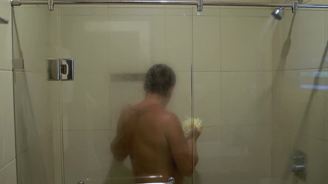 The man is washed with a sponge in the shower