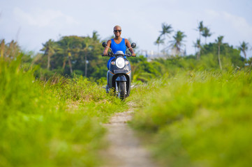 young attractive tourist afro American black woman riding motorbike  happy in beautiful Asia countryside along green rice fields smiling free on her scooter