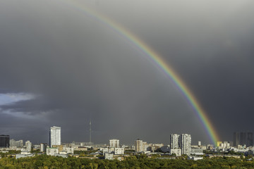 Rainbow in the gray sky after the rain in Moscow