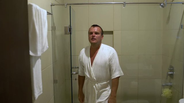 A Man Wears A Bathrobe And Comes Out Of The Shower