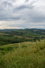 Bewölkter Himmel in der Toskana mit grünem Feld