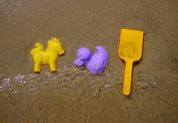 Fototapeta na wymiar colorful children's toys on the sandy beach in summer