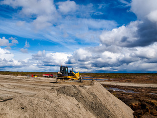 bulldozer makes dumping of sand in the swamp