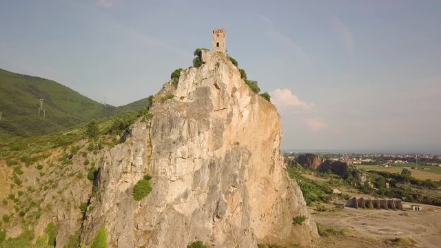 Piccola torre di un castello medievale su una rupe scoscesa. Torre di Caprona in provincia di Pisa. Vista aerea.