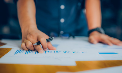 Hands of Businessman working on Laptop Computer with Data Charts