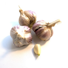 Heads of garlic and the cleaned clove on a white background.