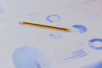 Pile of documents, smartphone and pen. Many graphs and charts. Concept image of data gathering.