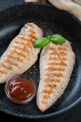 Closeup of grilled turkey breast fillet in a pan, selective focus, vertical shot