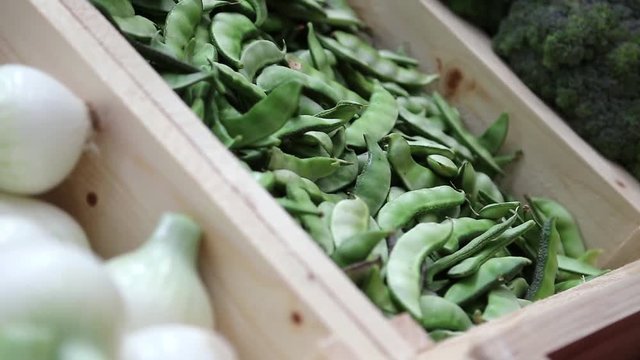 White onion, string beans and broccoli, shopboard with vegetables in market