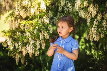 little girl in a dress in a flowering garden, portrait
