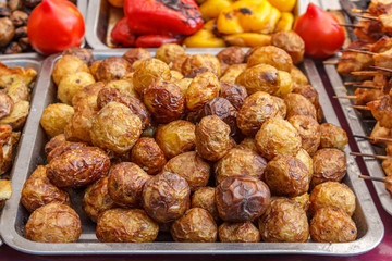 Whole roast potatoes on baking trays.