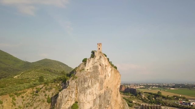Piccola torre di un castello medievale su una rupe scoscesa. Torre di Caprona in provincia di Pisa. Vista aerea.