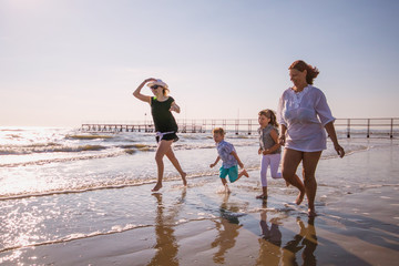 moms and son playing on the beach