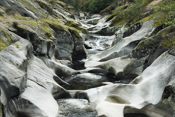Picture of the descent of a river with little flow between rocks with moss. Daytime image taken in...