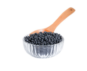 black beans with wooden spoon in clear Glass bowl on white background