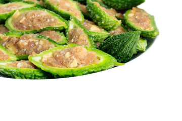 Bitter gourd pile with stuffed hack pork and garlic black pepper ingredient in plate on white background. vegetable herb Nourish the health body. Thai food