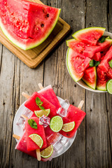 Sweet summer watermelon and lime popsicles with sliced watermelon and mint, on white marble background copy space