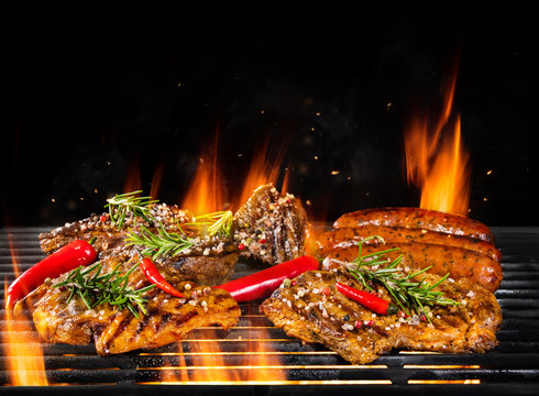 Various meat being grilled, isolated on black