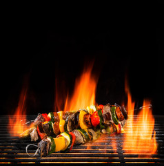 Delicious skewers on grill with Fire flames.