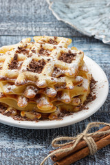 Homemade waffles with chocolate and powdered sugar.
