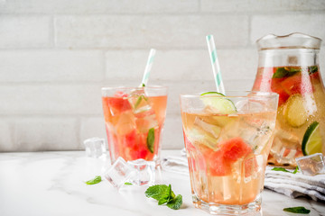 Iced watermelon and lime green tea with mint leaves, marble white background copy space