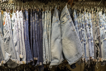 Men denim jeans in men clothes store- Shopping, fashion, style and people concept