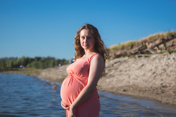Fototapeta na wymiar Happy young pregnant woman in nature