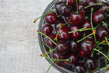 Spelled cherries on the white wooden background
