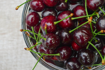 Spelled cherries on the white wooden background