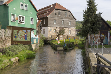 Fototapeta na wymiar Two bildings close to a little stream in Bad Bruckenau.