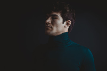 Dramatic portraits series with a young man on dark background