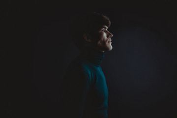 Dramatic portraits series with a young man on dark background