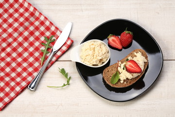 Slices of bread with white cheese and strawberries on top