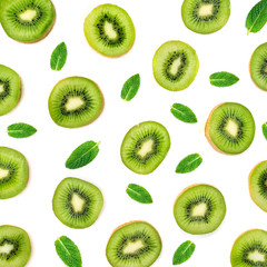 Fototapeta premium Fruit Pattern - Creative layout made of Kiwi fruits and peppermint leaves. Many slices of ripe Kiwifruit. Flat lay.