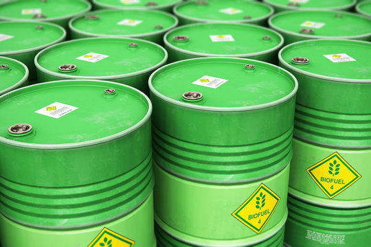 Group of rows of green stacked biofuel drums in storage warehouse