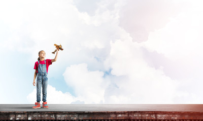 Concept of careless happy childhood with girl dreaming to become pilot