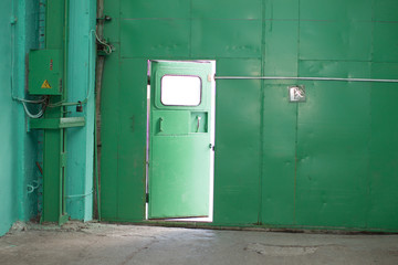 Green iron wall with half-open door