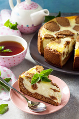 The concept of breakfast or relaxation. Chocolate New York cheesecake and mint tea cup on concrete background.
