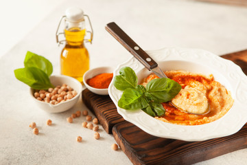Fresh classic hummus with basil in the bowl