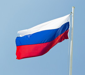 russian flag waving in the wind with blue sky as background