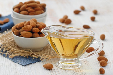Almond nuts in a bowl and almond oil